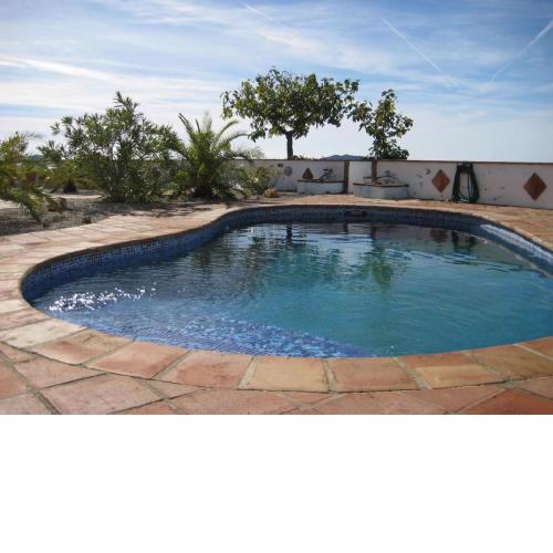 Eine große Villa mit überdachter Terrasse, sowie einem Garten mit Pool