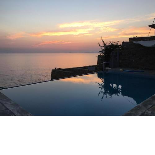Villa Afros on the waterfront with pool and steps leading to the sea in Koundouros
